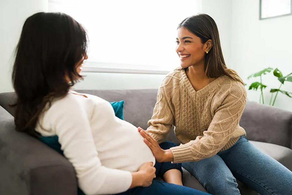 expectant mother sitting sofa home